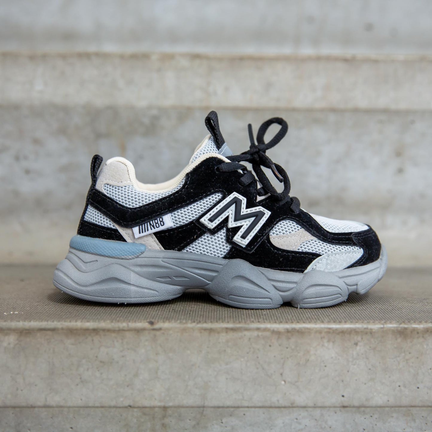 Zijaanzicht van de Flexxerz Black kindersneakers — sportieve en stijlvolle kinderschoenen met stevige zool