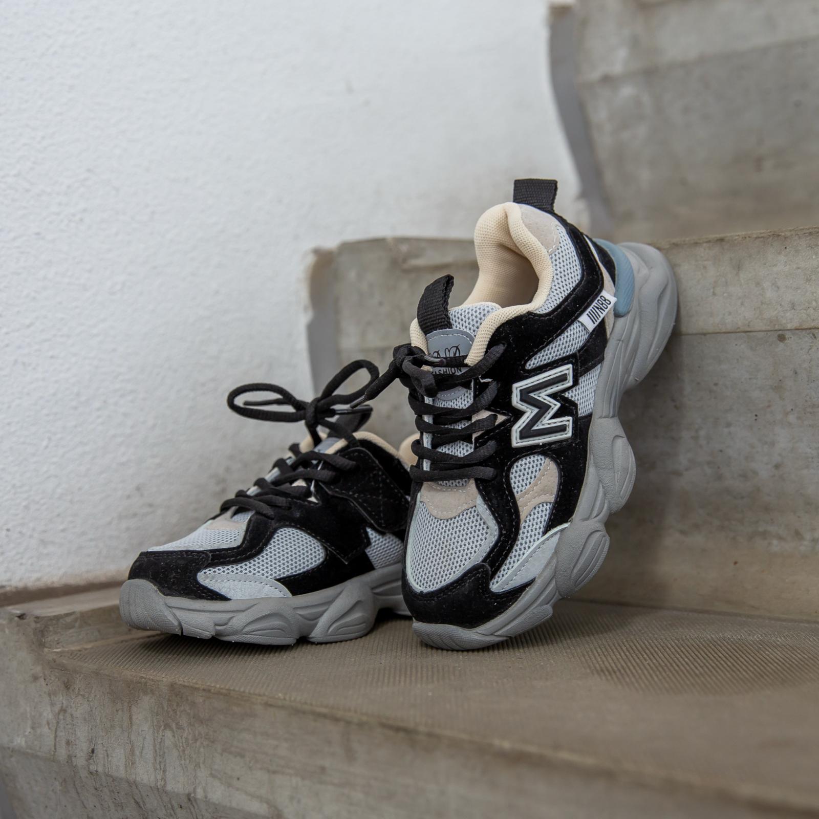 Flexxerz Black kindersneakers zijaanzicht schuin tegen trap — modern en comfortabel design voor actieve kids